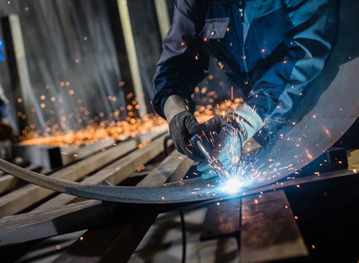 Welder performing structural fabrication of heavy steel